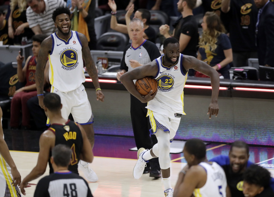 Golden State Warriors' Draymond Green (23) and Jordan Bell celebrate at the end of Game 4 of basketball's NBA Finals against the Cleveland Cavaliers, Friday, June 8, 2018, in Cleveland. The Warriors defeated the Cavaliers 108-85 and swept the series.