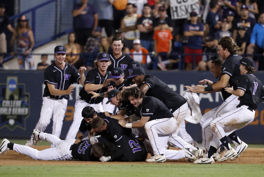 Washington players celebrate after beating the Cal State Fullerton in the 10th inning of an NCAA college baseball tournament super regional game in Fullerton, Calif., Sunday, June 10, 2018. Washington won, 6-5.