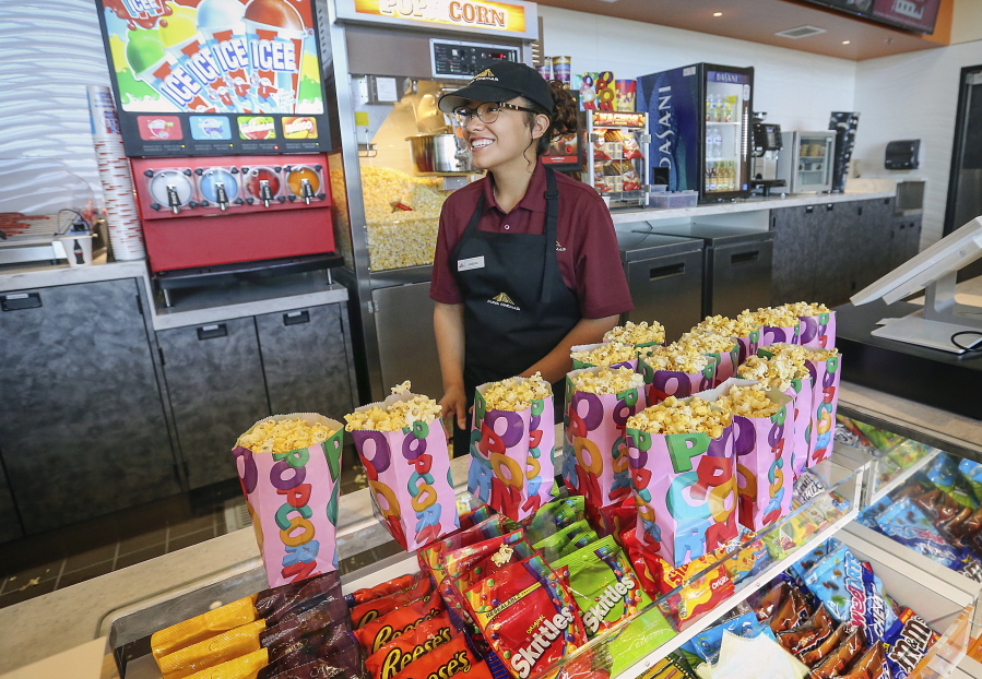 In this May 17, 2018 photo, McFarland High senior Victoria Sharp works at the food concession and is one of the high school students that acquired one of the coveted jobs at the Maya Cinemas Theater in Delano, Calif. For around a decade, the farm worker city of Delano, has lacked a movie theater. Residents from this largely Latino community had to travel nearly 40 miles to see the latest film a drive advocates say was rare since around a third of the population lives in poverty. This week, Moctesuma Esparza, a well-known Latino movie producer, opened his latest Maya Cinemas theater this month in the Central California city of 53,000 people as part of his ongoing effort to open movie theaters in poor, U.S. rural areas that lack basic entertainment options. (Henry A.
