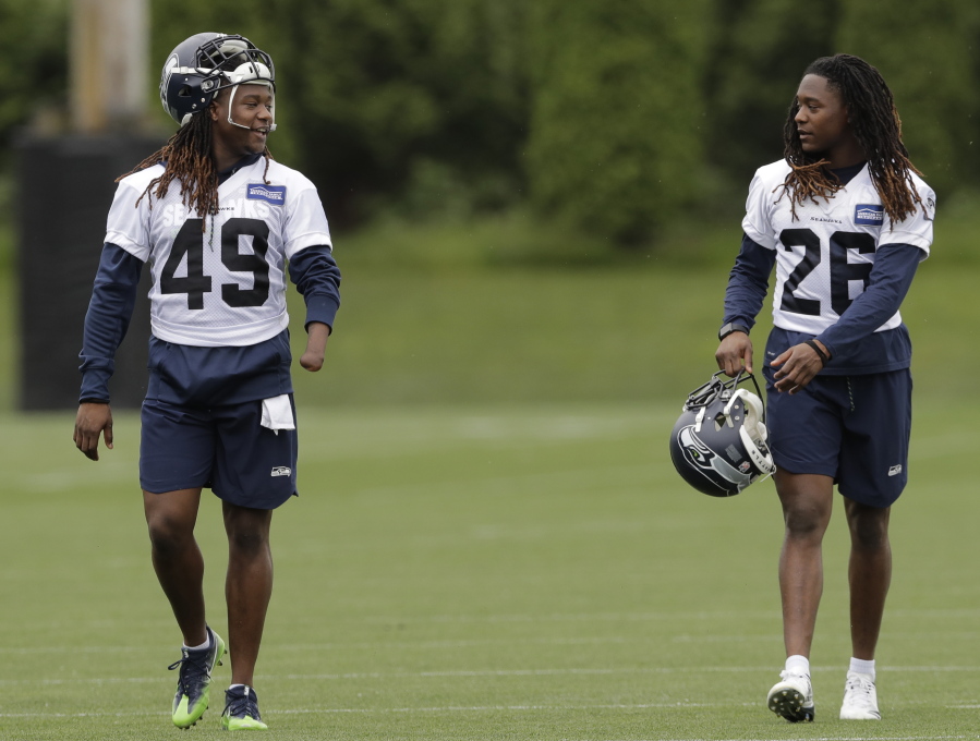 Seattle Seahawks linebacker Shaquem Griffin, left, walks with his twin brother, cornerback Shaquill Griffin, right, following NFL football practice, Thursday, June 14, 2018, in Renton, Wash. (AP Photo/Ted S.
