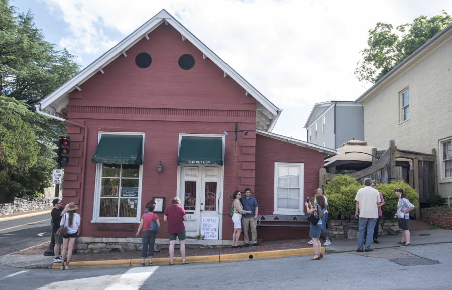 Passers-by gather to take photos June 23 in front of the Red Hen Restaurant in Lexington, Va. The restaurant has become internationally famous since ousting White House press secretary Sarah Huckabee Sanders.