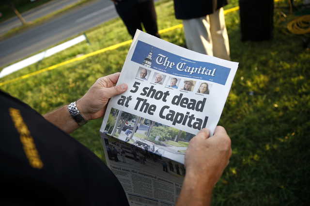 Steve Schuh, county executive of Anne Arundel County, holds a copy of The Capital Gazette near the scene of a shooting at the newspaper's office June 29 in Annapolis, Md. A man armed with smoke grenades and a shotgun attacked journalists in the building June 28 killing five people before police quickly stormed the building and arrested him, police and witnesses said.