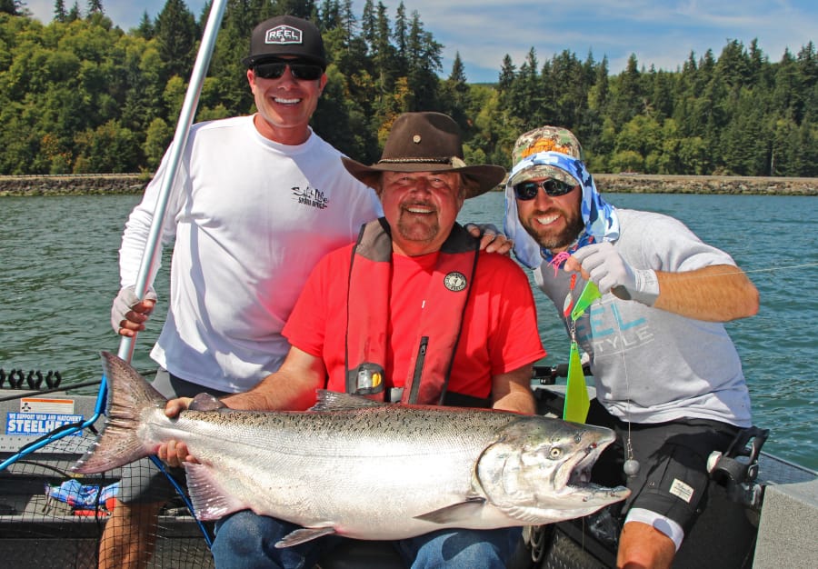 Buzz Ramsey, center, and friends celebrate landing a 32-pound Chinook caught last year at Buoy 10. Chinook could be in short supply this season.