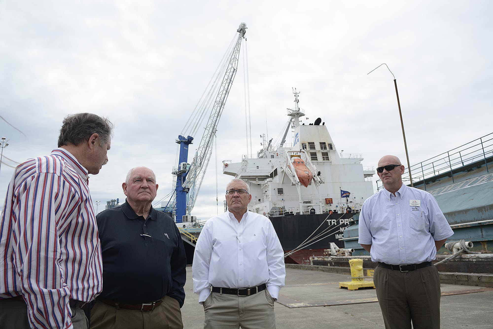 Bruce Reed of Tidewater Transportation &amp; Terminals, from left, talks with Sonny Perdue, Rob Rich of Shaver Transportation and Mark Wilson of Port of Kalama on Wednesday morning, July 4, 2018.