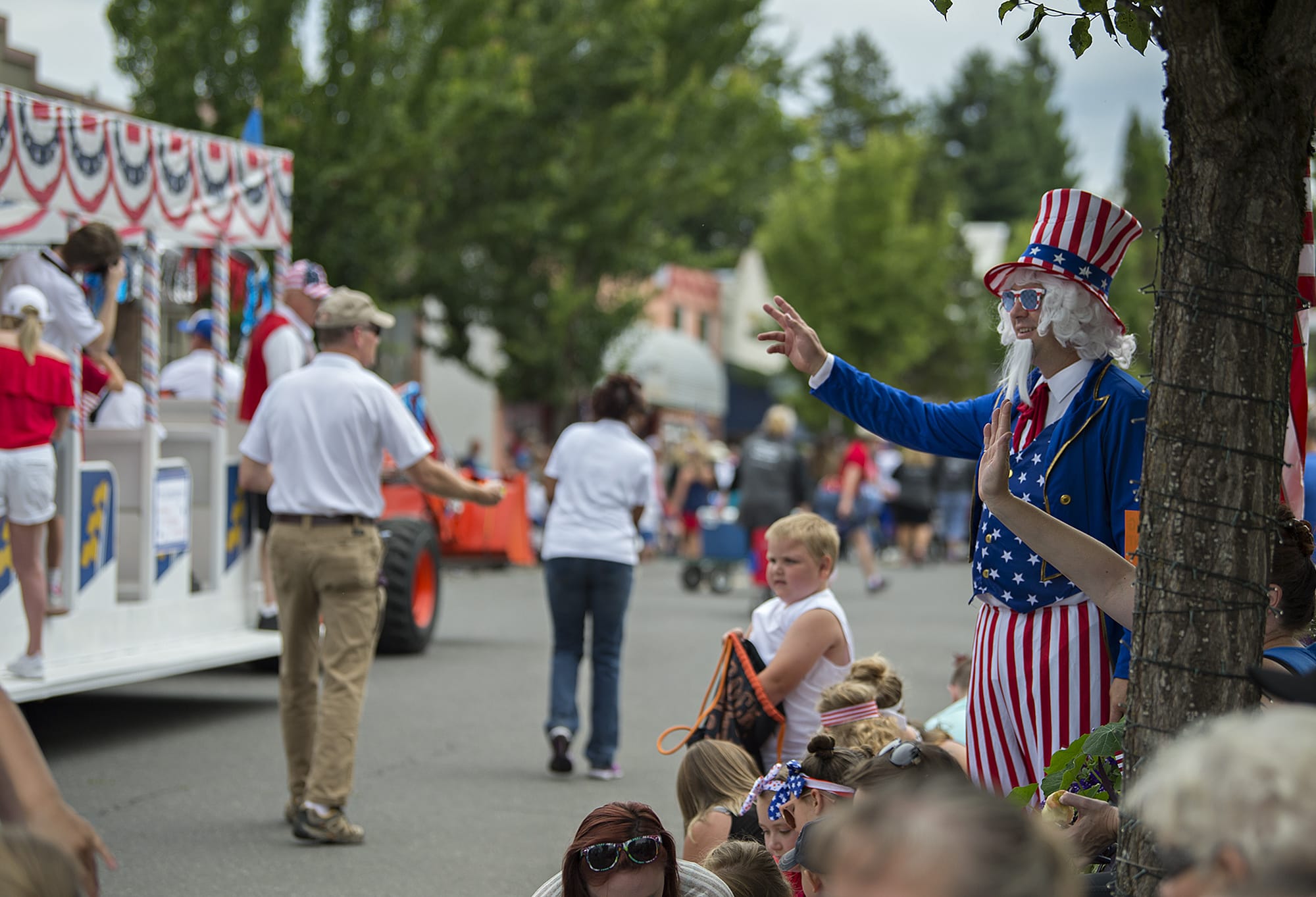 Ed Martin of Ridgefield, right, gets into the spirit of the Fourth of July dressed as Uncle Sam as he enjoys the annual parade from his spot along Pioneer Street on Wednesday morning. Martin said the holiday has special meaning for him because he became an American citizen in 2014. He said he was excited to join the celebration this year. "Loved it last year, couldn't miss it this year," he said.