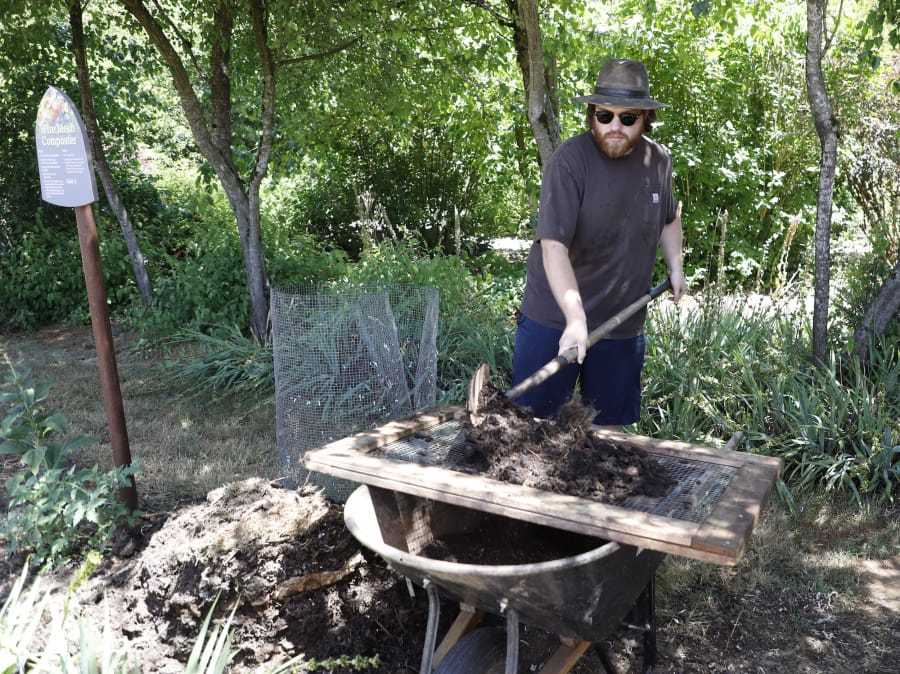 Eric Stricker, a volunteer with Clark County Green Schools, demonstrates filtering larger chunks due back to the pile from compost soil during a demonstration and open house on composting Sunday at the Art in the Garden event in Brush Prairie.