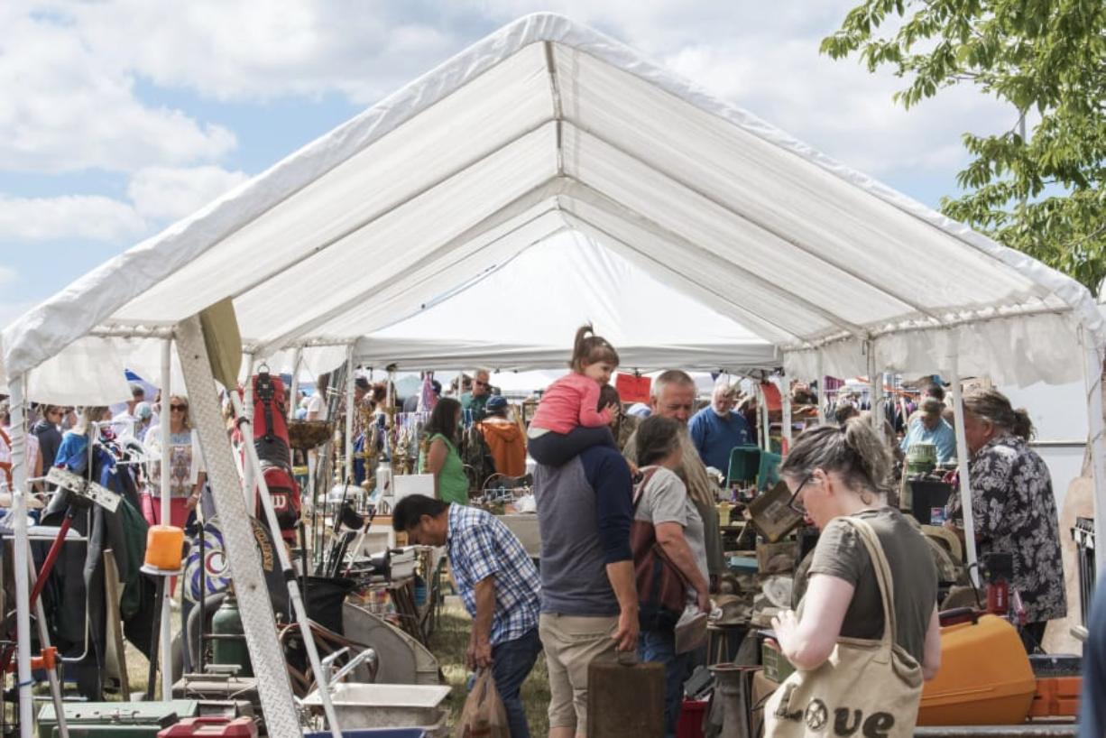 Shoppers at the NW’s Largest Garage Sale & Vintage Sale browse under a shaded stall at the Clark County Event Center at the Fairgrounds on Saturday. Organizers said there were 500 vendors there hoping to sell to thousands of shoppers.