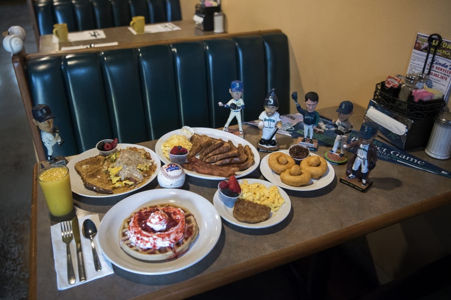 The offerings at Linda’s Homeplate include the half order of Linda’s Hash, from left clockwise, the French toast with bacon and scrambled eggs, homemade doughnuts with chocolate frosting, and the waffle with strawberries and whipped cream plus a side of eggs and a sausage patty.