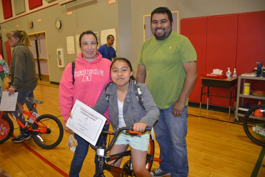 Washougal: Hathaway Elementary School fourth-grader Abigail Picho with parents Graciela and Facundo Picho, and a new bicycle she won through the school’s Strive for Five attendance program.