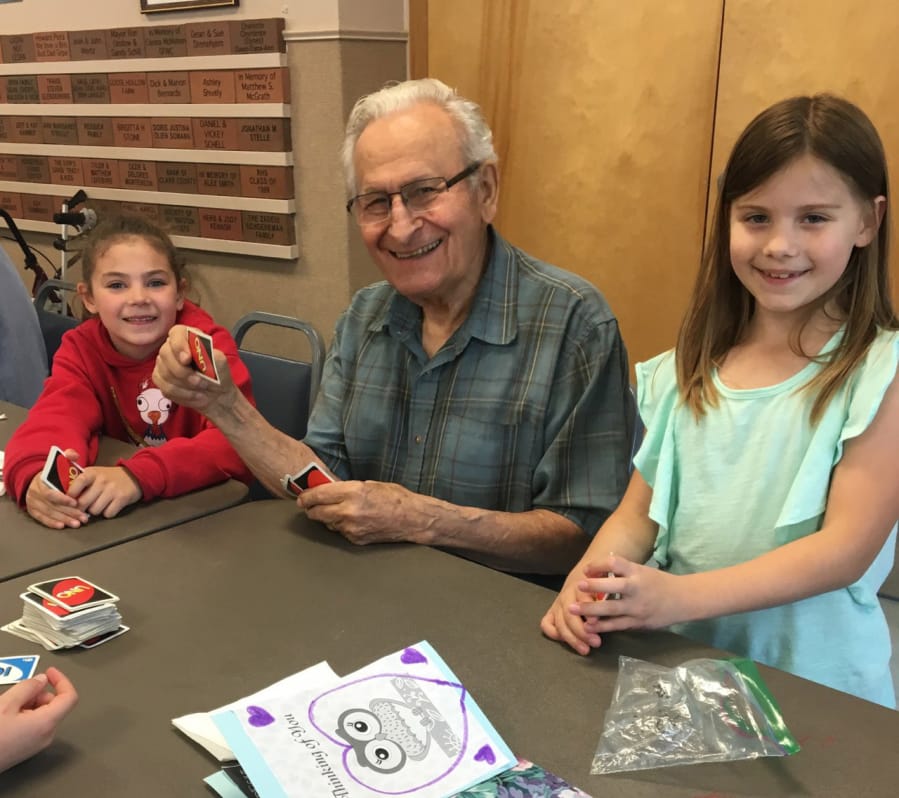 Ridgefield: Union Ridge Elementary School second-graders Lizzy Bloom, left, and Clara Bruguier, right, play cards with Ken Carson at the Ridgefield Community Center during a monthly visit to meet with local seniors.