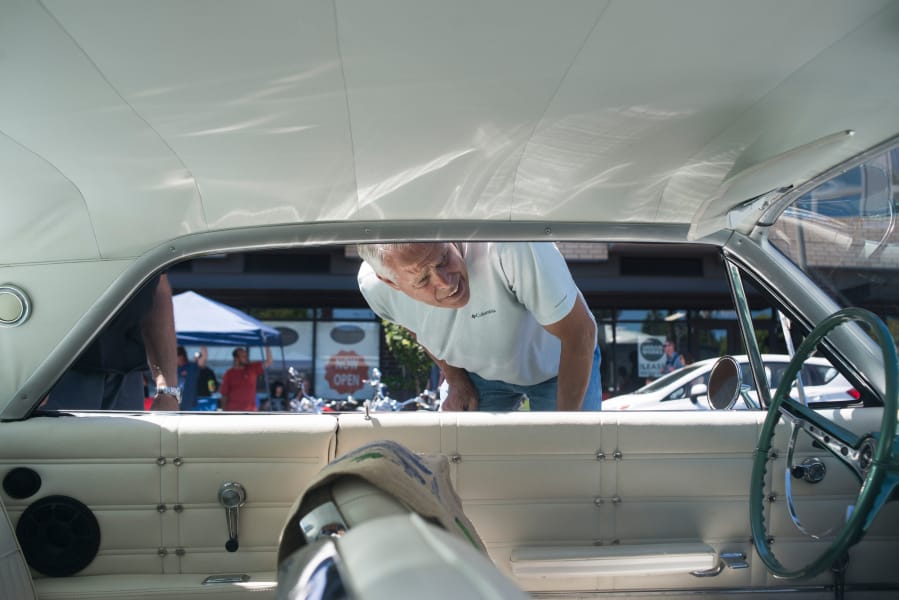 John Petty looks at the interior of a 1963 Chevrolet Impala on Saturday during Cruise the Couve on Main Street in downtown Vancouver.