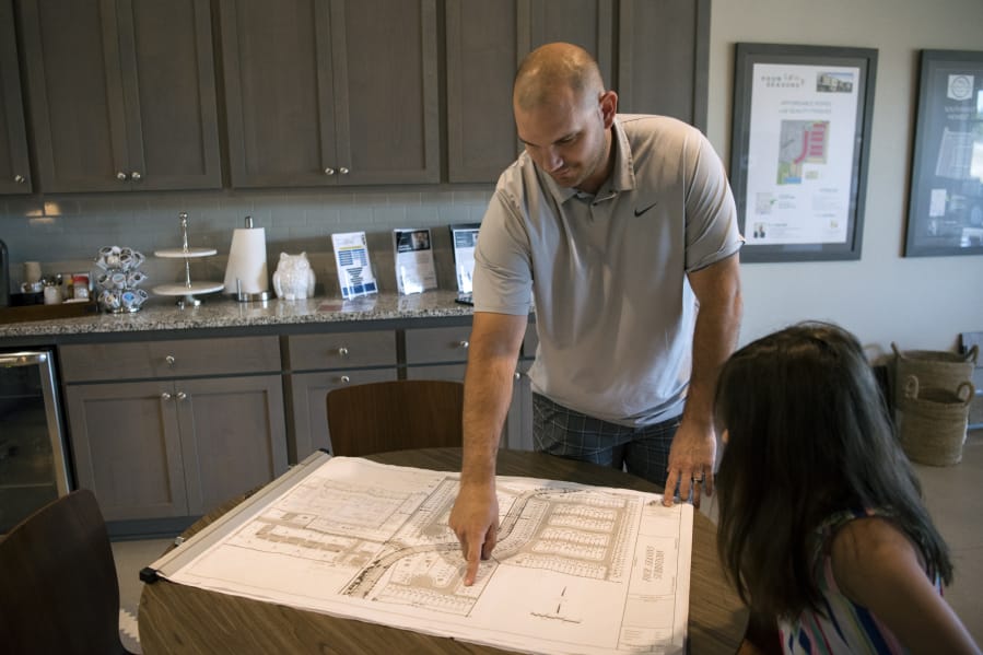 Jeff Wilkins, left, and his daughter, Emily, both of Vancouver, spot their new home at the Four Seasons Lane subdivision, one of Ginn Development’s projects in Vancouver. The homes are priced sell for less than Clark County’s median home price. Reservations for the first homes are underway.