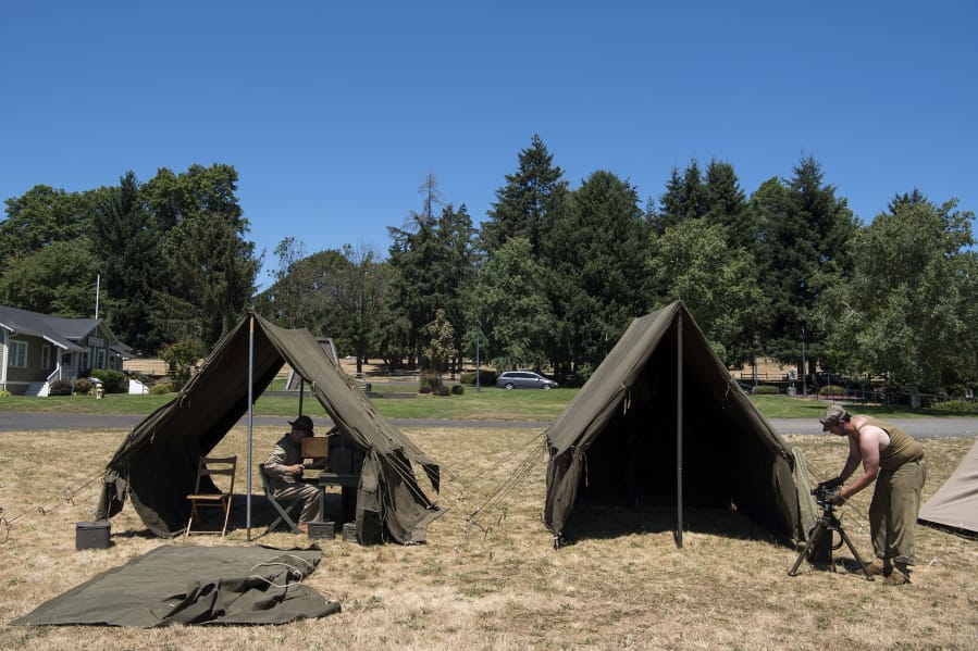 Corky Porter of Salem, Ore., left, and Jordan Stray of Tumwater set up their camps Friday at the World War II living history encampment put on by Living History Group Northwest and hosted by the National Park Service at Fort Vancouver National Historic Site.