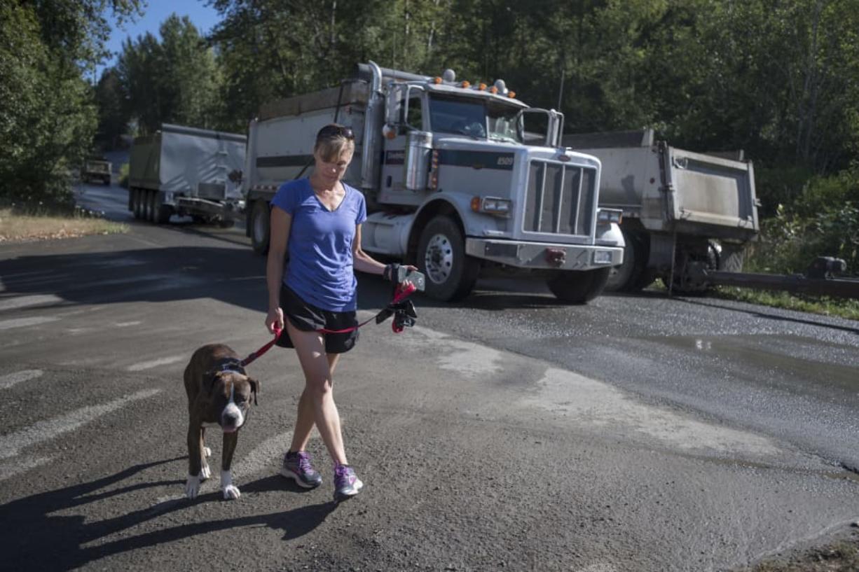 Rachel Grice and her dog, Rusty, 3, take their morning stroll just as truck traffic from a nearby mine picks up.