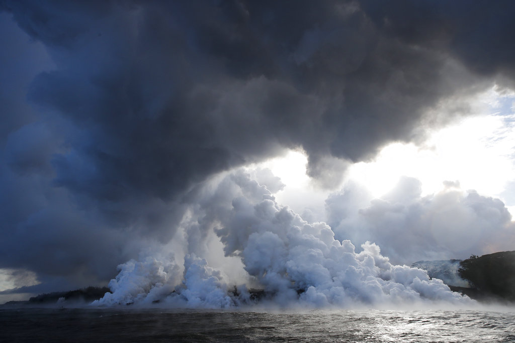 In this May 20, 2018 file photo, plumes of steam rise as lava enters the ocean near Pahoa, Hawaii. An explosion sent lava flying through the roof of a tour boat off Hawaii's Big Island, injuring at least 13 people Monday, July 16, 2018, officials said. The people were aboard a tour boat that takes visitors to see lava from an erupting volcano plunge into the ocean. (AP Photo/Jae C.