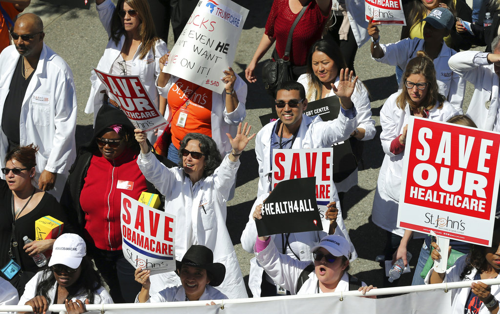 File - In this March 23, 2017, file photo, health care professionals join hundreds of people marching through downtown Los Angeles protesting President Donald Trump's plan to dismantle the Affordable Care Act. California and 17 other states that sued the Trump administration over its decision to cut off Affordable Care Act subsidies say a workaround has largely succeeded. The assessment came in a court filing late Monday, July 16, 2018, in which the states asked U.S. Judge Vince Chhabria to put their lawsuit on hold.