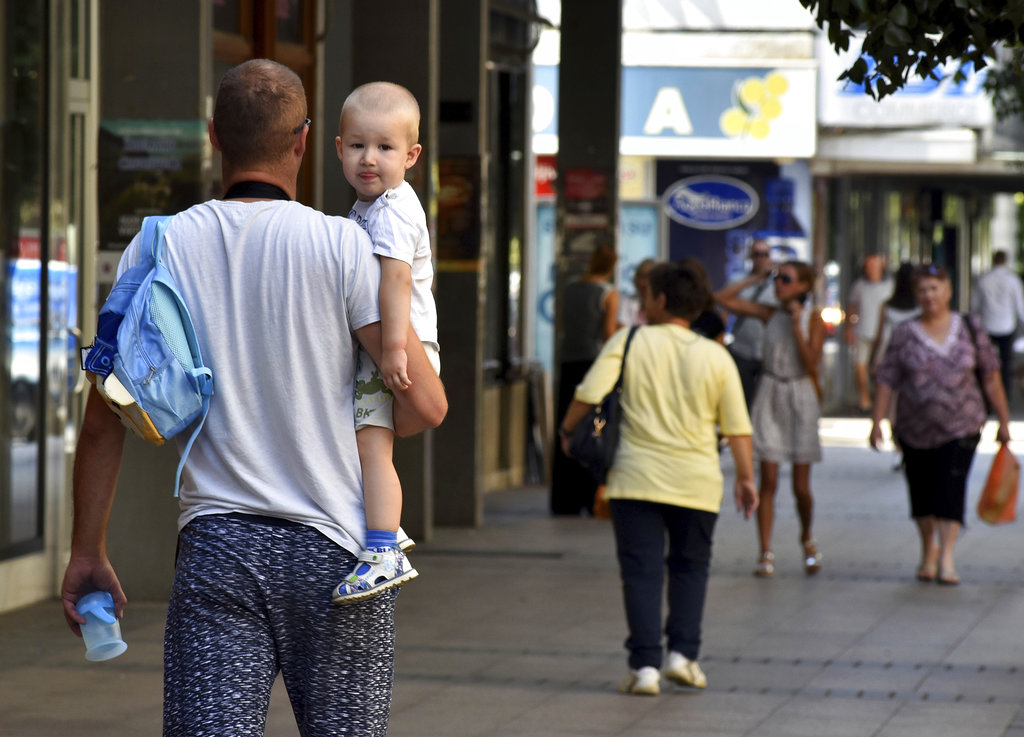 People walk trough the street in Montenegro's capital Podgorica, Thursday, July 19, 2018.  U.S.