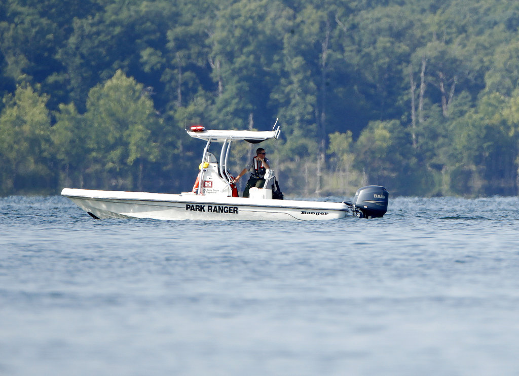 A park ranger patrols  an area Friday, July 20, 2018, near where a duck boat capsized the night before resulting in at least 13 deaths on Table Rock Lake in Branson, Mo. Workers were still searching for four people on the boat that were unaccounted for.
