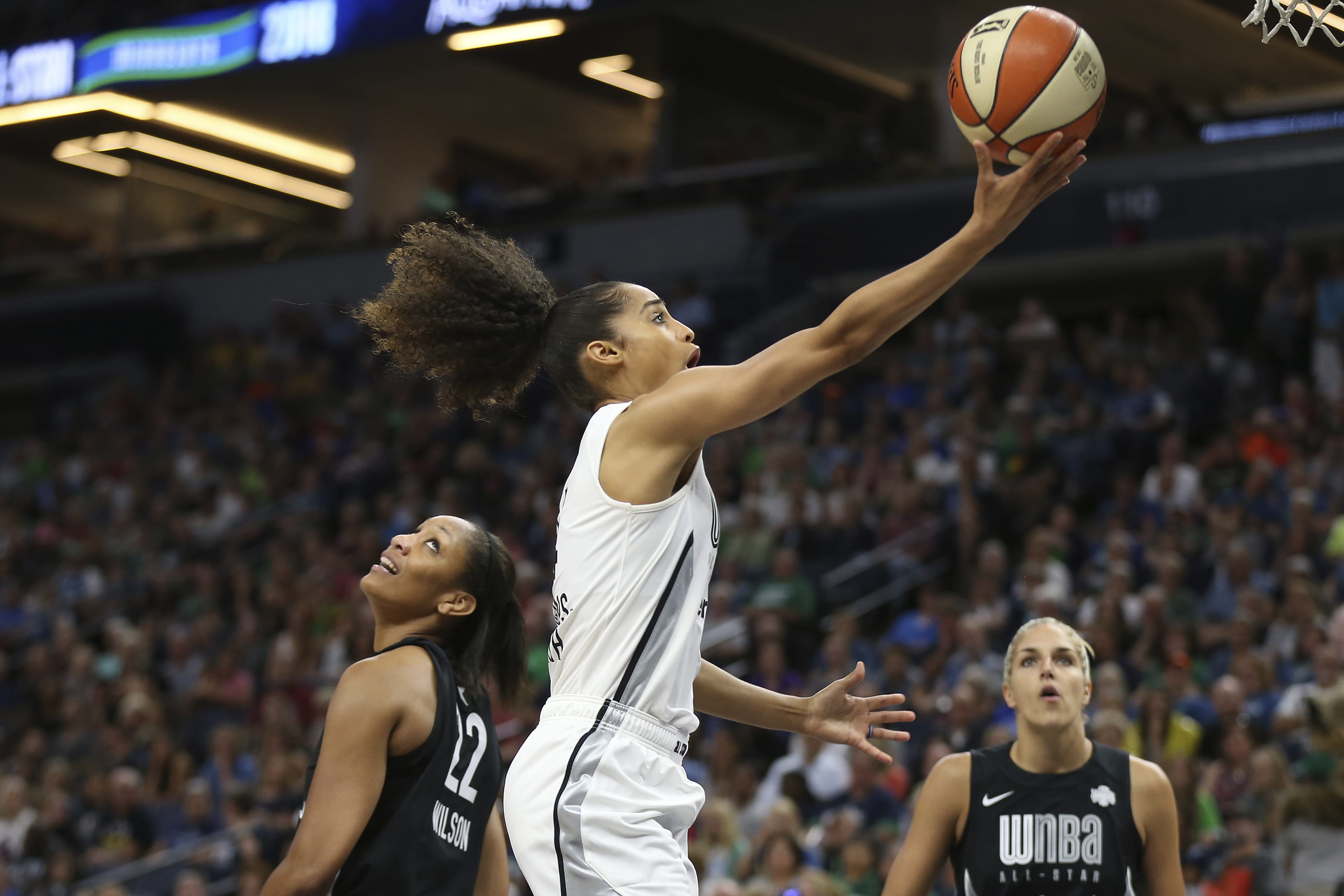 Team Candace Parker's Skylar Diggins-Smith, center, goes to the basket against Team Delle Donne's A'ja Wilson (22) in the first half of the WNBA All-Star basketball game Saturday, July 28, 2018 in Minneapolis.