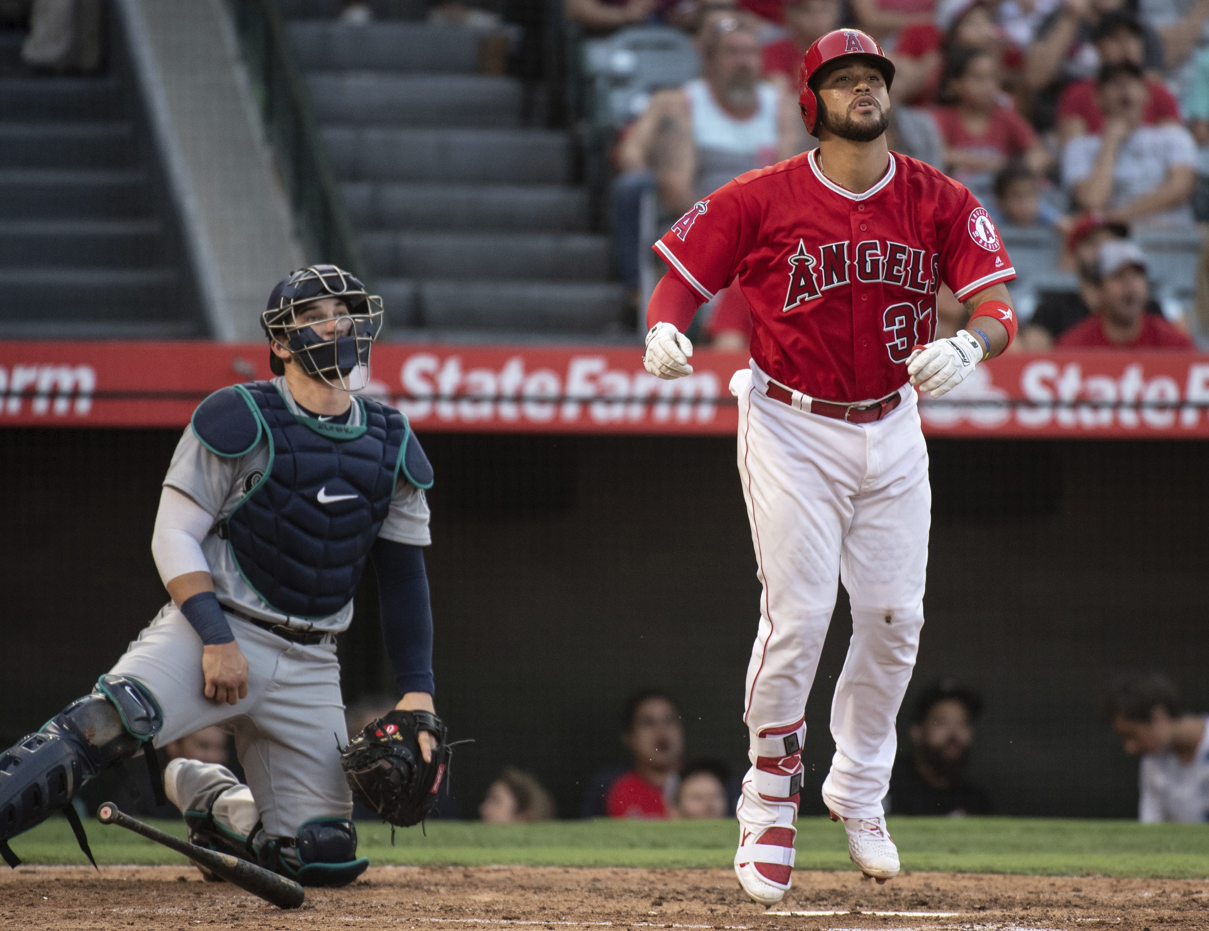 Los Angeles Angels' Francisco Arcia, right, watches his three-run home run next to Seattle Mariners catcher Mike Zunino during the third inning of baseball game in Anaheim, Calif., Saturday, July 28, 2018.