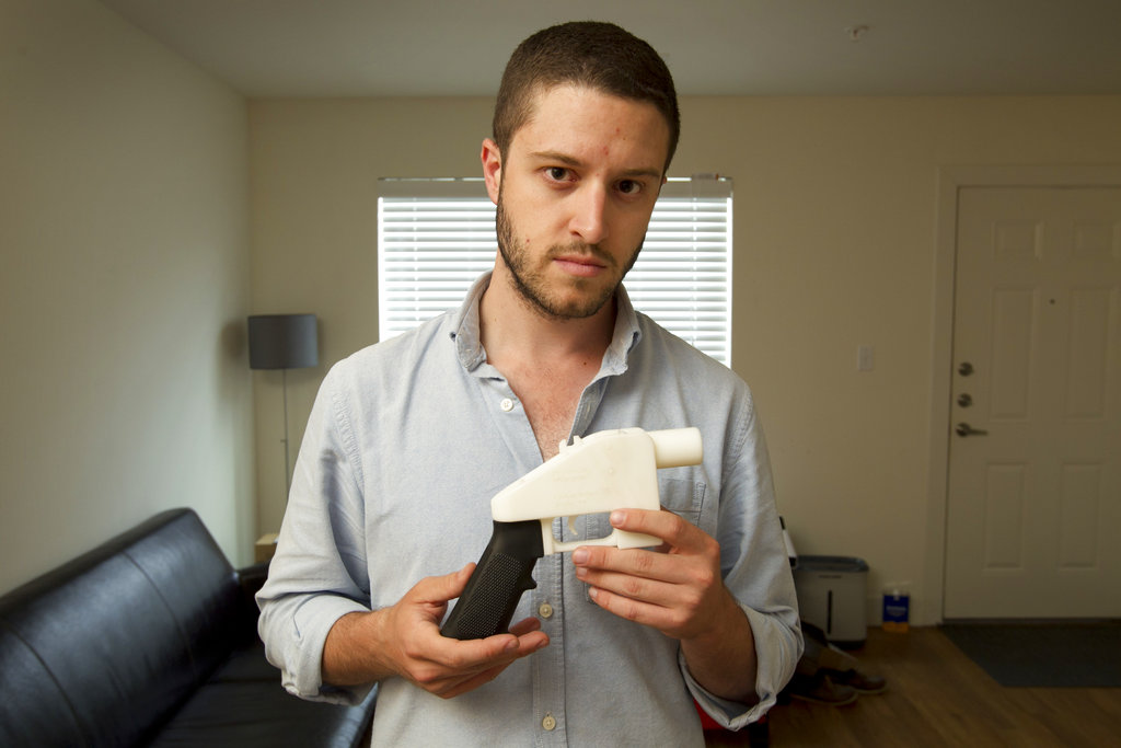 FILE - In this May 10, 2013, file photo, Cody Wilson, the founder of Defense Distributed, shows a plastic handgun made on a 3D-printer at his home in Austin, Texas. Eight states filed suit Monday, July 30, 2018, against the Trump administration over its decision to allow a Texas company to publish downloadable blueprints for a 3D-printed gun, contending the hard-to-trace plastic weapons are a boon to terrorists and criminals and threaten public safety.