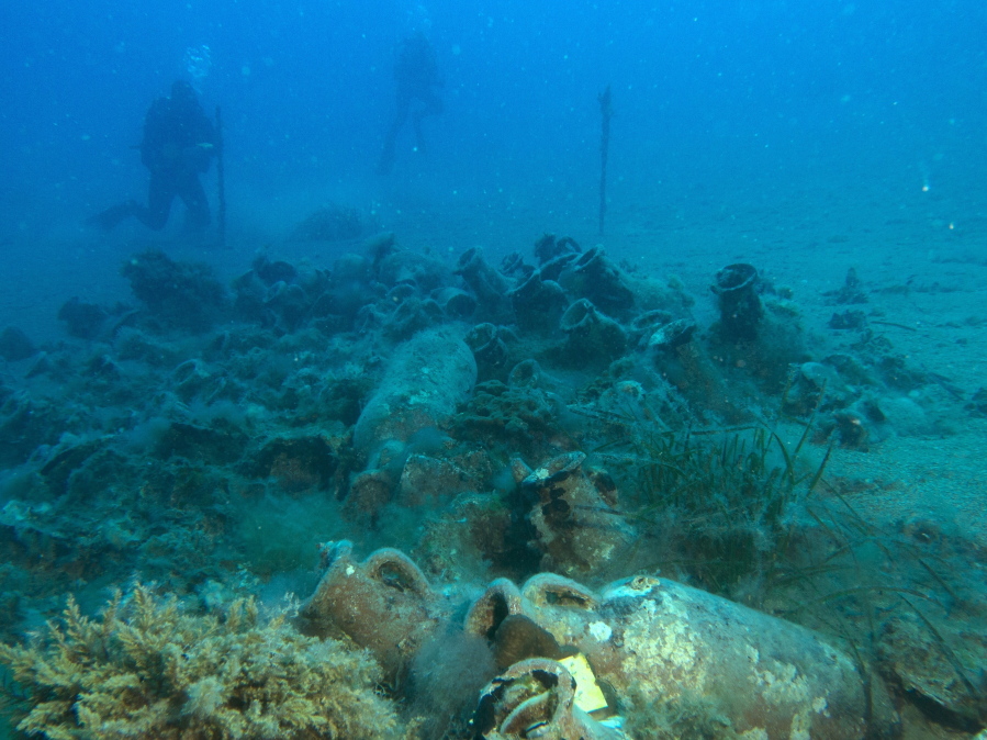 FILE - In this Wednesday, July 19, 2017 file photo, maritime ecologist Derek Smith of the RPM Nautical Foundation, back left, takes measurements on sedimentation at the site of a 4th century A.D. shipwreck off the coast of Albania. On the seabed off the rugged shores of Albania, one of the world's least explored underwater coastlines, lies a wealth of treasures and researchers are urging Albanian authorities to build a museum to display the artefacts.