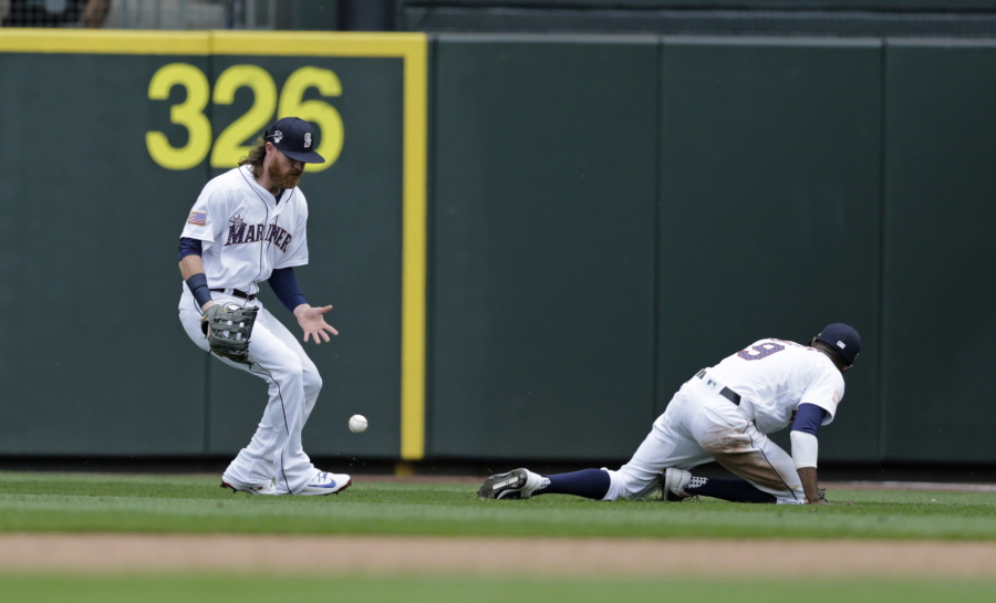 The ball hit by Los Angeles Angels’ Kole Calhoun drops between Seattle Mariners right fielder Ben Game and second baseman Dee Gordon during eighth inning of a baseball game Wednesday, July 4, 2018, in Seattle.