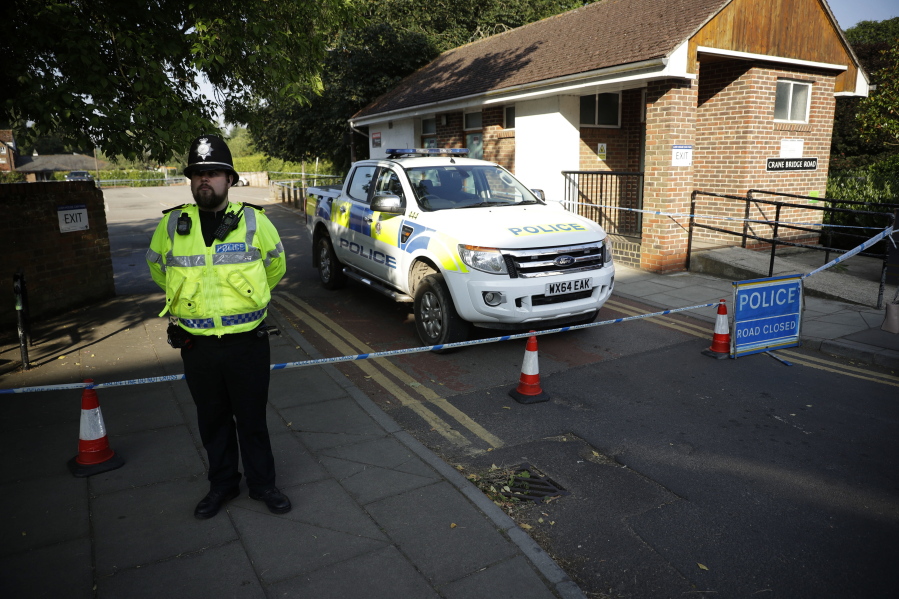 A British police officer guards a cordon which was extended overnight to include the Lush House car park adjacent to the Queen Elizabeth Gardens park in Salisbury, England, on Thursday. British officials ware seeking clues Thursday in the rush to understand how two Britons were exposed to the military-grade nerve agent Novichok.