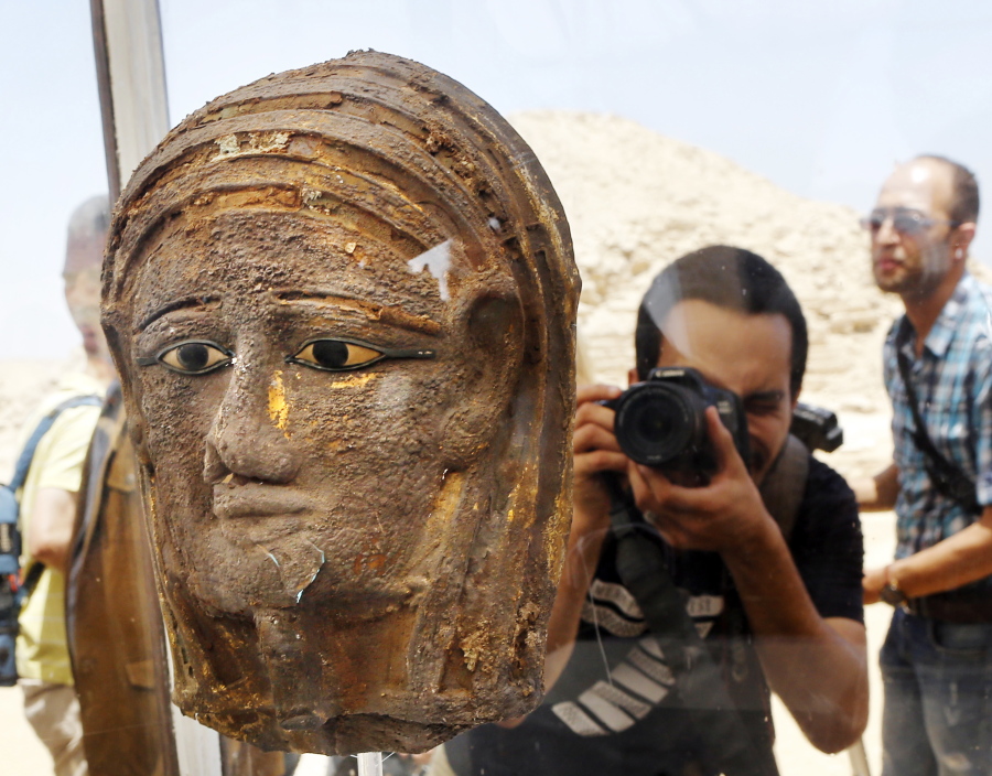 A photographer films a gilded silver mummy mask found on the face of the mummy of the second priest of Mut, as it is displayed during a press conference in front of the step pyramid of Saqqara, in Giza, Saturday, July 14, 2018. Archaeologists say they have discovered a mummification workshop dating back some 2,500 years at an ancient necropolis near Egypt’s famed pyramids.