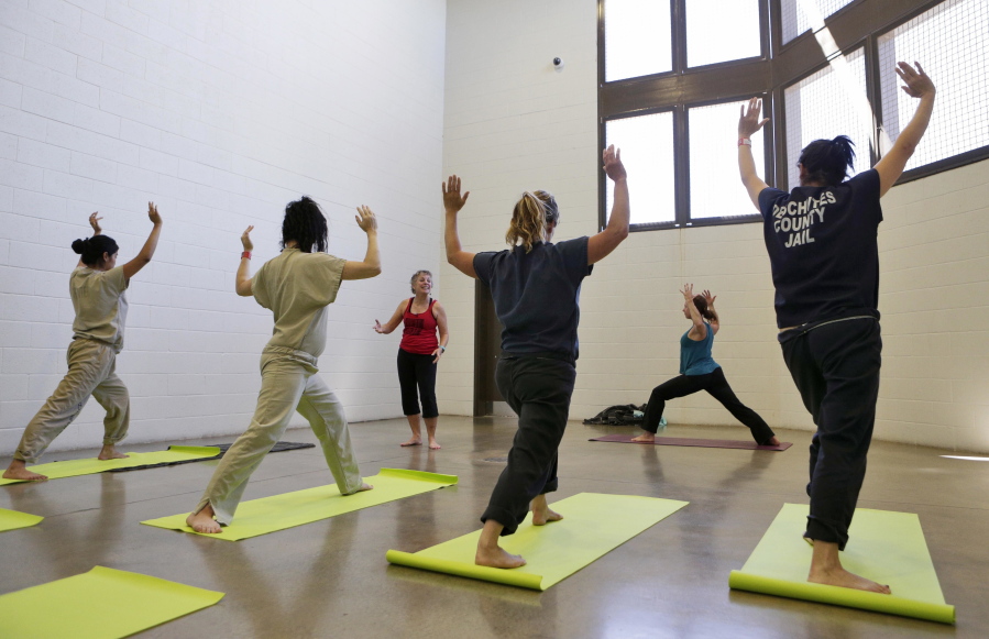 Instructor Nancy Lumpkin, left rear, talks Deschutes County Jail inmates through yoga poses as Emily Anderson, right center, demonstrates during a class offered for female inmates at the jail on July 12 in Bend, Ore.