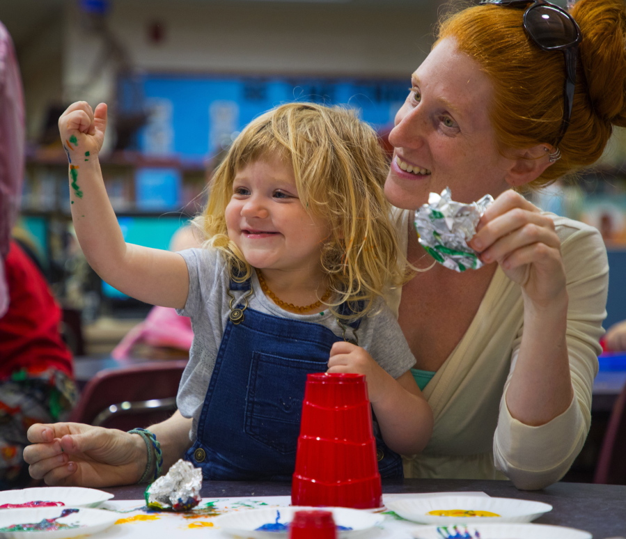 In this May 10, 2018 photo, Harley, 2, and Reagan Rufner participate in painting time in the 1-2-3- Grow & Learn program in the library at Roosevelt Elementary in Vancouver, Wash.