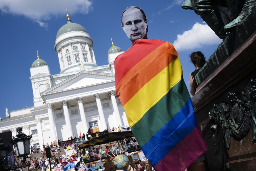 A man with a Putin mask and a rainbow flag attends a rally against the policy of U.S. President Donald Trump and Russian President Vladimir Putin in central Helsinki, Sunday, July 15, 2018. President Trump and President Putin will meet in Finland's capital on Monday, July 16, 2018.