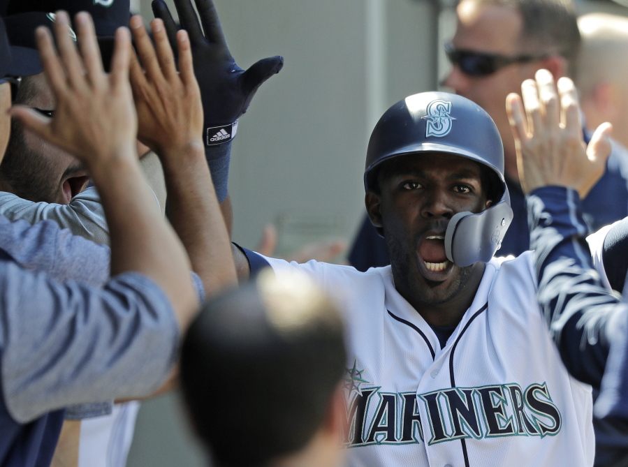 Seattle Mariners’ Guillermo Heredia is congratulated in the dugout after he scored against the San Francisco Giants during the eighth inning of a baseball game Wednesday, July 25, 2018, in Seattle. The Mariners won 3-2. (AP Photo/Ted S.