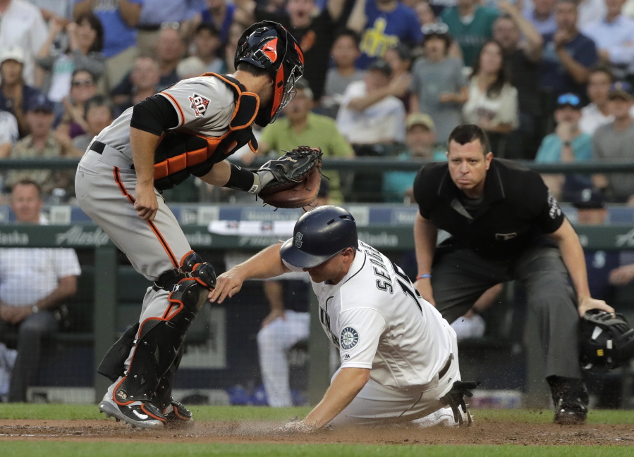 Seattle Mariners’ Kyle Seager is tagged out at home by San Francisco Giants catcher Buster Posey as he tried to score on a single by Mike Zunino during the fourth inning of a baseball game Tuesday, July 24, 2018, in Seattle. (AP Photo/Ted S.
