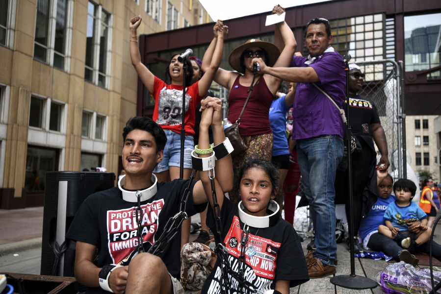 James Gutierrez, 15, and his sister, Lilah, 8, wore chains during a demonstration against the Trump administration’s immigration policies Saturday, June 30, 2018.(Aaron Lavinsky/Star Tribune via AP)