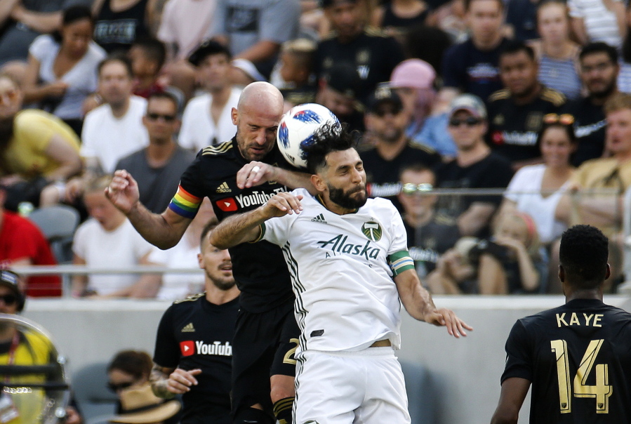 Los Angeles FC defender Laurent Ciman, left, of Belgium, and Portland Timbers midfielder Diego Valeri, center, of Argentina, battle for a head ball in the second half of an MLS soccer game in Los Angeles, Sunday, July 15, 2018. The game ended in a 0-0 draw. (AP Photo/Ringo H.W.