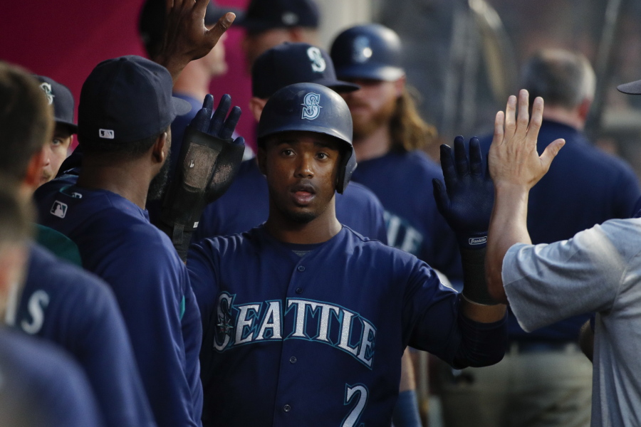 Seattle Mariners' Jean Segura, center, is greeted by teammates after scoring during the fourth inning of the team's baseball game against the Los Angeles Angels, Wednesday, July 11, 2018, in Anaheim, Calif. (AP Photo/Jae C.