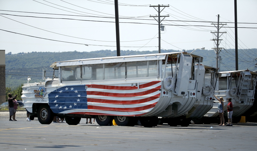 People look at idled duck boats in the parking lot of Ride the Ducks Saturday, July 21, 2018 in Branson, Mo. One of the company’s duck boats capsized Thursday night resulting in several deaths on Table Rock Lake.