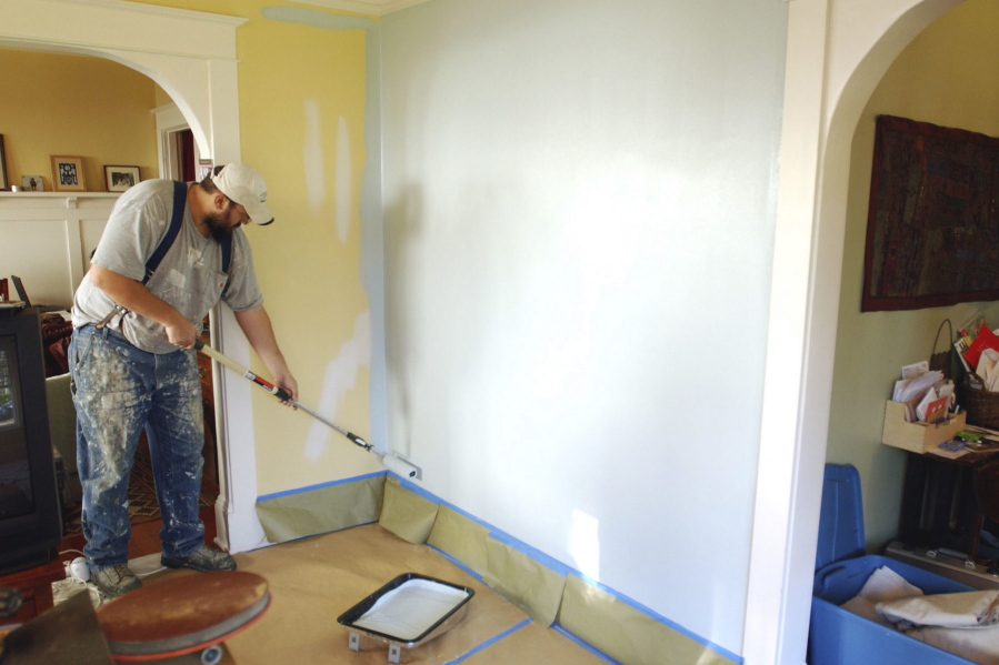 FILE- In this Dec. 5, 2008, file photo, painting contractor Andrew Lohr finishes the first coat on his living room wall in Portland, Ore. Home improvements can rejuvenate a stale dwelling. A fresh coat of paint on the walls can make for a quick makeover.