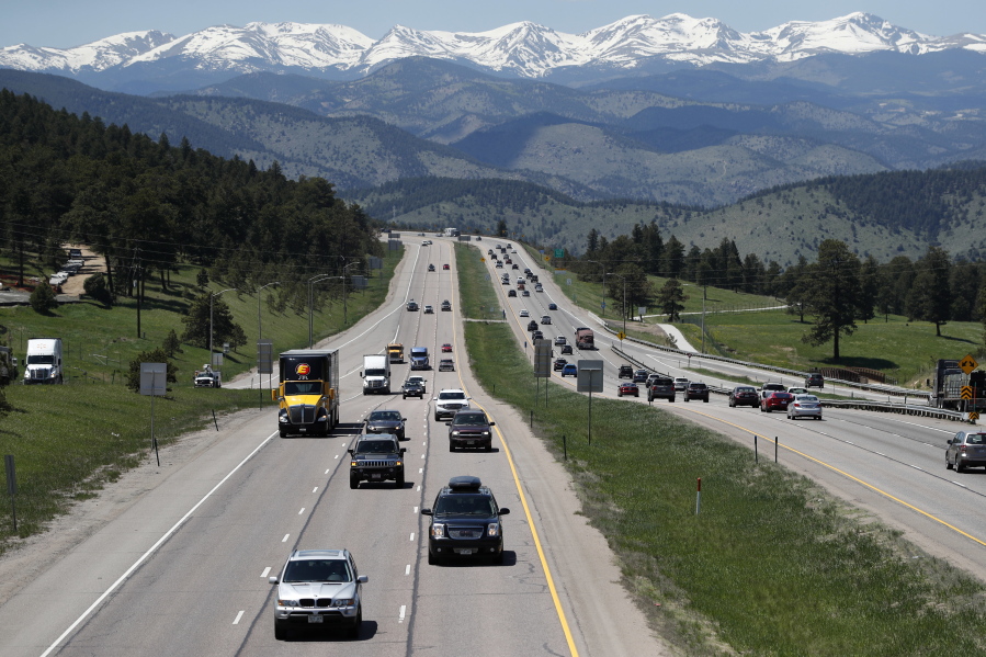 Motorists guide their vehicles down Interstate 70 near Evergreen, Colo.