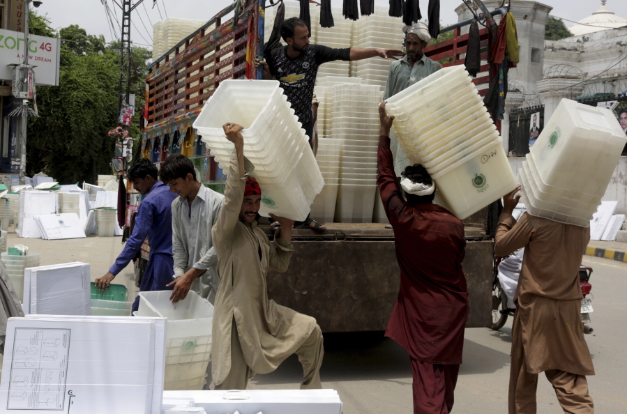 Workers collect ballot boxes and polling material after polling in Lahore, Pakistan, Thursday, July 26, 2018. The suicide attack outside the polling station in Quetta which killed dozens of people, underscored the difficulties the majority Muslim nation faces on its wobbly journey toward sustained democracy. (AP Photo/K.M.