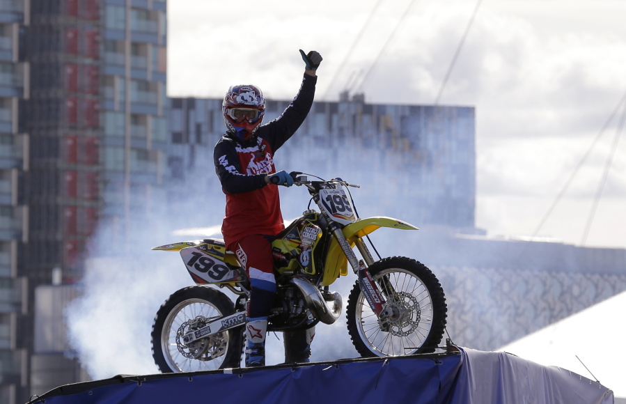 FILE - In this Oct. 5, 2017, file photo, Nitro Circus ringleader and stunt professional Travis Pastrana celebrates after he performed the first motorcycle backflip over the River Thames with a 75-foot wide gap between two floating barges, in London. Fifty years after Evel Knievel so famously wiped out trying to jump the fountain at Caesar's Palace, action sports wild man Travis Pastrana will try to nail the stunt Sunday night, July 8, 2018, in the finale of a triple-header tribute to the late daredevil.