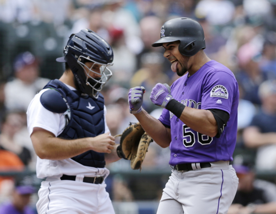 Colorado Rockies’ Noel Cuevas, right, celebrates as he reaches home after hitting a three-run home run on a pitch from Seattle Mariners starter James Paxton during the seventh inning of a baseball game, Saturday, July 7, 2018, in Seattle.