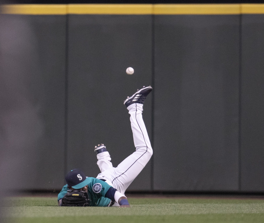 Seattle Mariners center fielder Guillermo Heredia cannot get to a two-run triple hit by Colorado Rockies’ Tony Wolters off relief pitcher Roenis Elias during the sixth inning of a baseball game Friday, July 6, 2018, in Seattle.