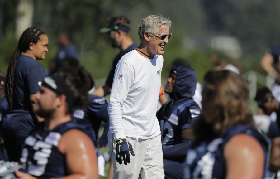 Seattle Seahawks head coach Pete Carroll smiles and he greets players at NFL football training camp, Thursday, July 26, 2018, in Renton, Wash. (AP Photo/Ted S.