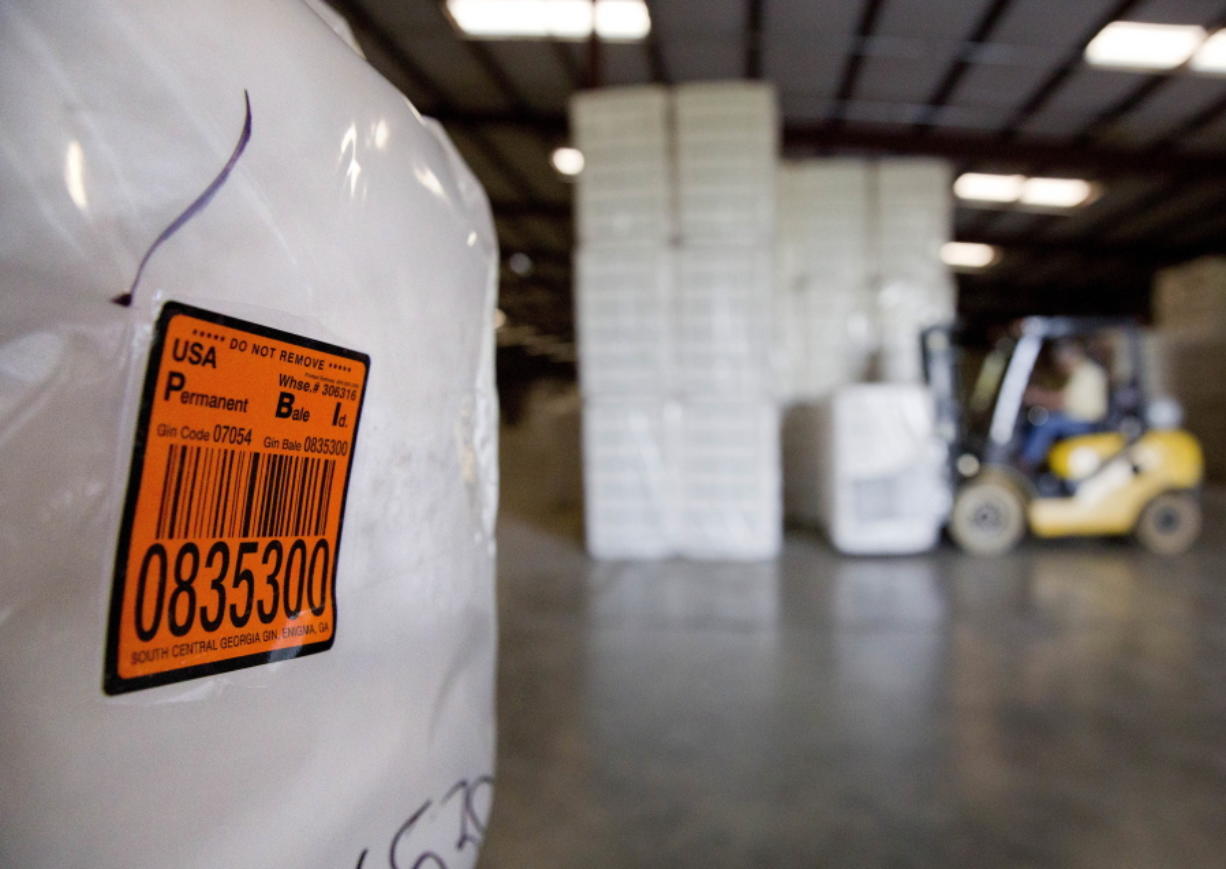 FILE - In this June 21, 2018, file photo, a bale of cotton sits packed and labeled while waiting to be shipped from the South Central Georgia Gin Company in Enigma, Ga. The company estimates that 40-50 percent of the cotton processed at the gin is exported out of the country, China being one of the main recipients.