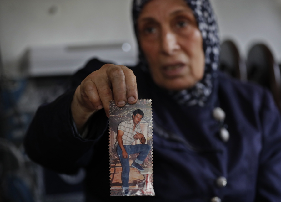 Dahouk al-Omar, 68, an unregistered Syrian refugee woman, shows an old picture of her son Fadi who resettled in U.S, Chicago state, during an interview with The Associated Press, at her house, in Tripoli, north Lebanon. al-Omar hoping she can join her son in Chicago. The Trump administration travel ban has thrown yet another obstacle in the way of Syrian refugees whose status in neighboring countries is already extremely uncertain.