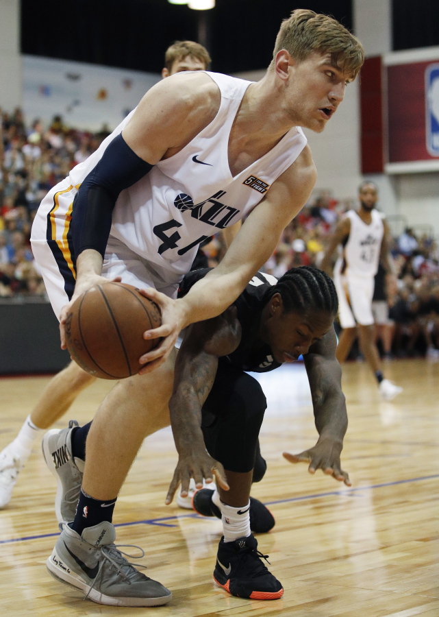Utah Jazz’s Isaac Haas, left, battles for the ball with Portland Trail Blazers’ Archie Goodwin during the second half of an NBA summer league basketball game Saturday, July 7, 2018, in Las Vegas.