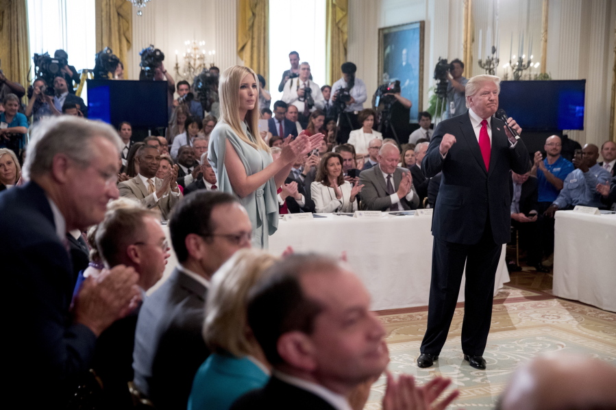 President Donald Trump, accompanied by his daughter Ivanka Trump, center left, pumps his fist after signing an Executive Order that establishes a National Council for the American Worker during a ceremony in the East Room of the White House, Thursday, July 19, 2018, in Washington.