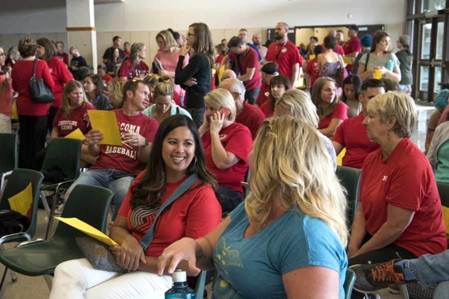 Nicole Chandler, a teacher at Wy’east Middle School, left, and Jennifer Smith, a teacher at Frontier Middle School, right, chat in the overflow cafeteria space before the Evergreen Education Association general membership meeting at Evergreen High School in Vancouver on Thursday.